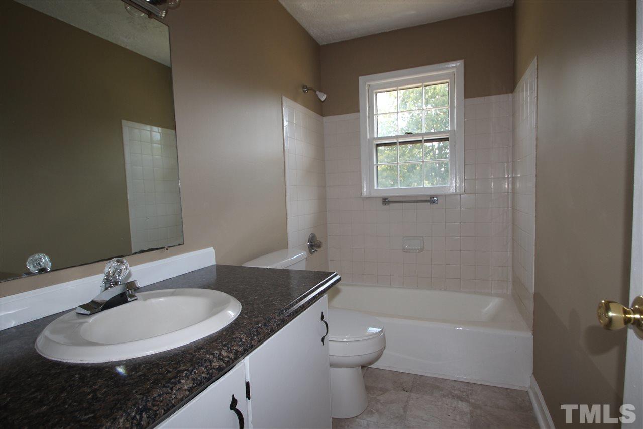 510 Fontaine Road Roxboro, NC 27574 - Photo 6 of 10 a bathroom with a granite countertop sink toilet a mirror and a tub