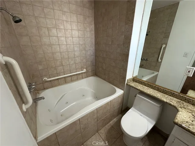 a white toilet sitting next to a bath tub