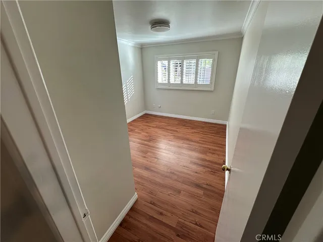 en empty room with wooden floor and windows
