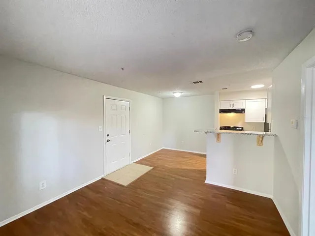 a view of a big room with wooden floor and a bathroom
