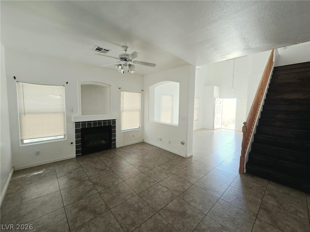 9034 West Rochelle Avenue Las Vegas, NV 89147 - Photo 4 of 8 A versatile living area features a hearth fireplace and direct access to an upper-level staircase.