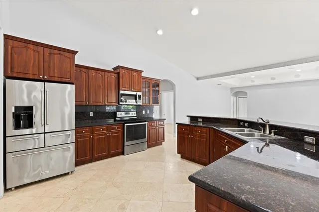 a kitchen with stainless steel appliances granite countertop a sink stove and refrigerator