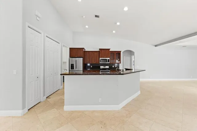 a view of kitchen with stainless steel appliances granite countertop refrigerator sink and stove