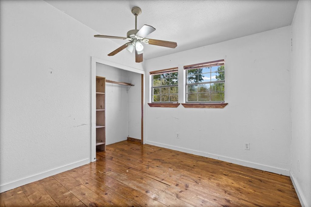 555 Harmon Hills Road, Unit A Dripping Springs, TX 78620 - Photo 23 of 29 Bright windows and warm hardwood floors create a welcoming atmosphere in this spacious bedroom.