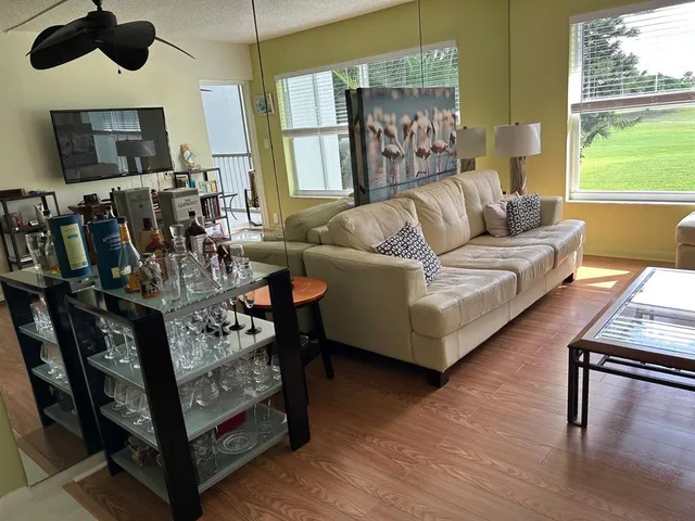 a living room with furniture a flat screen tv and a large window