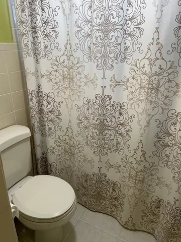 a bathroom with a toilet and a shower curtain