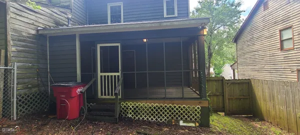 a view of a house with a door and wooden fence