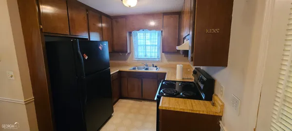 a kitchen with a refrigerator and a stove