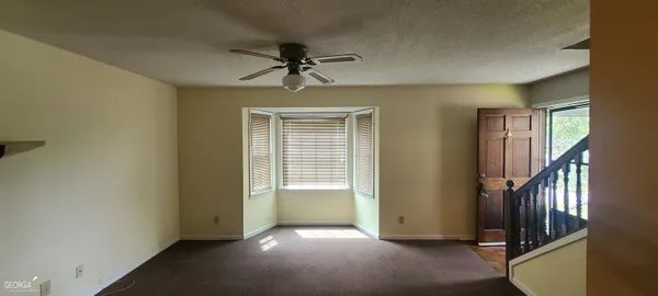 a view of a livingroom with a ceiling fan and window