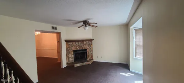 a view of an empty room with a fireplace and a window