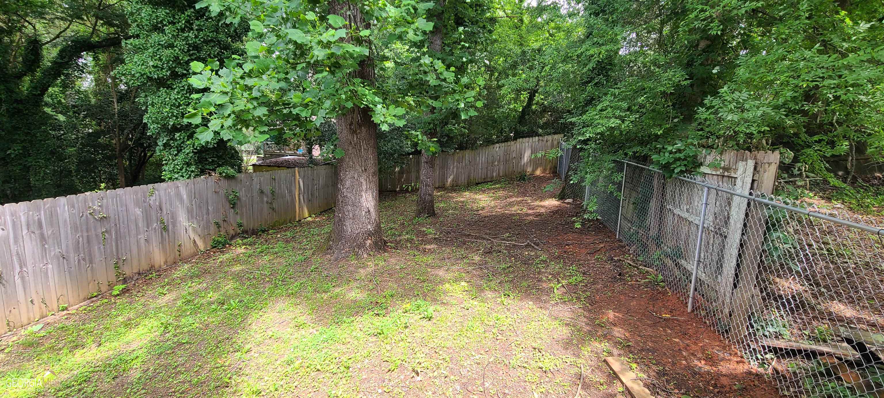 4353 Barrington Place Macon, GA 31210 - Photo 10 of 12 a backyard of a house with large trees and wooden fence