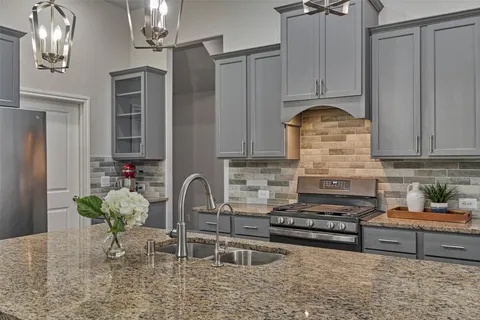 a kitchen with stainless steel appliances granite countertop a stove a sink and a refrigerator