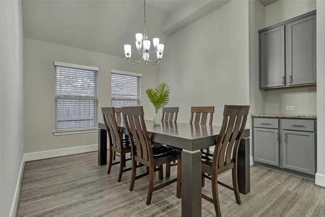 a view of a dining room with furniture a chandelier and wooden floor