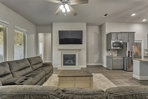 a living room with furniture a fireplace and a flat screen tv