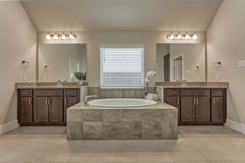 a spacious bathroom with a sink a large mirror and a bathtub