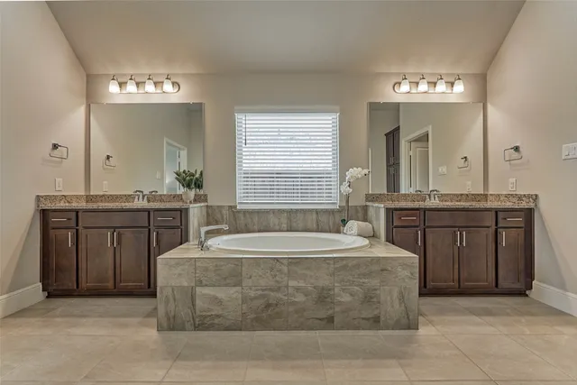 a spacious bathroom with a sink a large mirror and a bathtub