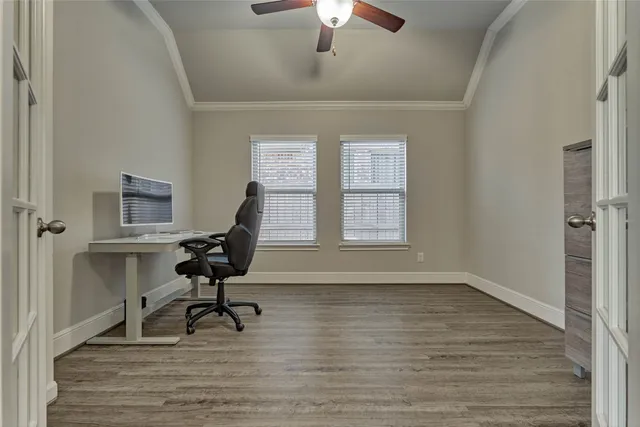 a view of a workspace with wooden floor and a window