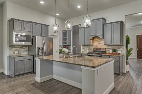 a kitchen with stainless steel appliances granite countertop a sink stove and refrigerator