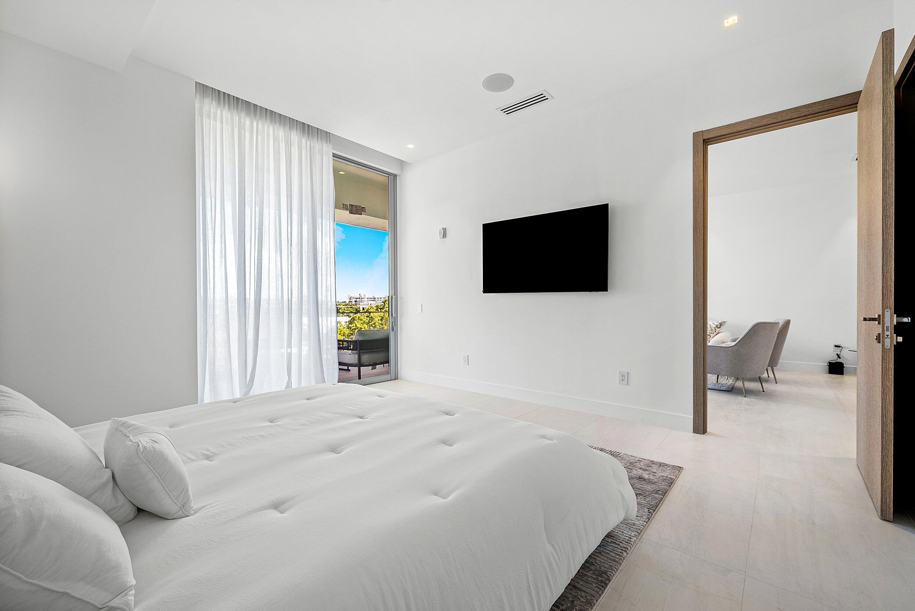 246 Northeast 6th Avenue, Unit 3B Delray Beach, FL 33483 - Photo 11 of 23 a bedroom with a bed and a flat screen tv