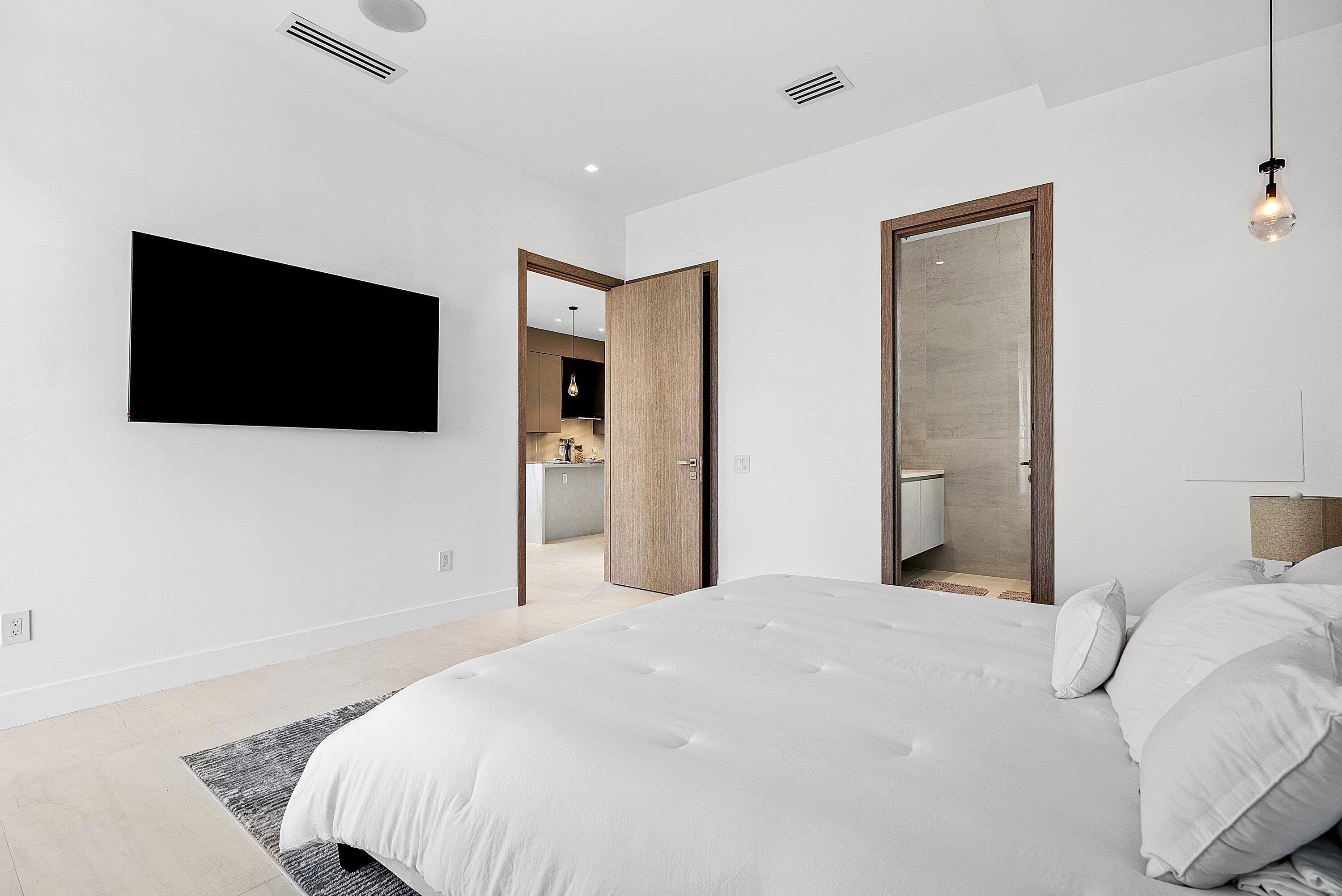 246 Northeast 6th Avenue, Unit 3B Delray Beach, FL 33483 - Photo 12 of 23 a bedroom with a bed and a flat screen tv