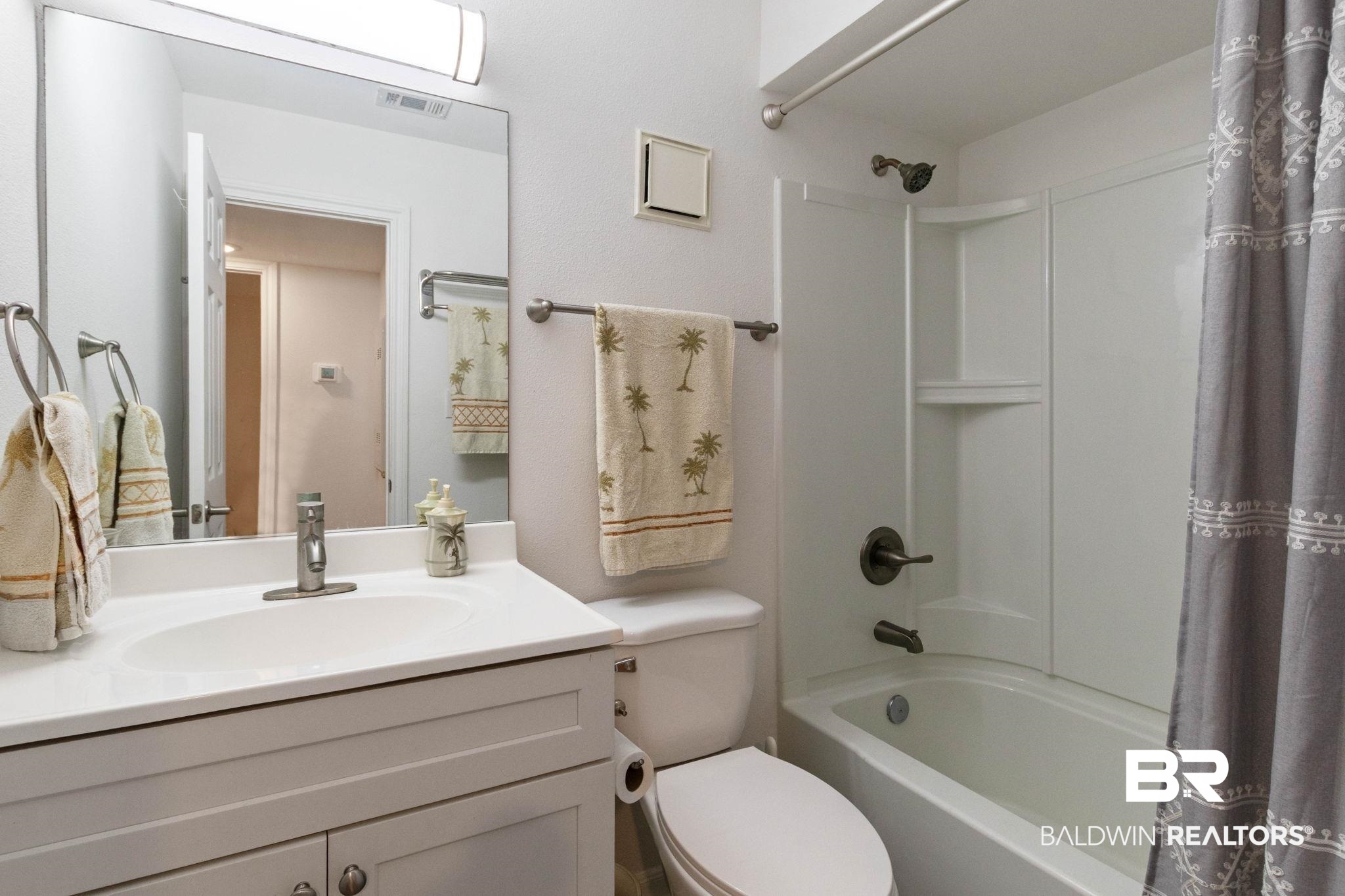 400 Plantation Road, Unit 4501 Gulf Shores, AL 36542 - Photo 14 of 30 Bathroom featuring a white vanity with an integrated sink, polished chrome faucet, and a wall-mounted mirror