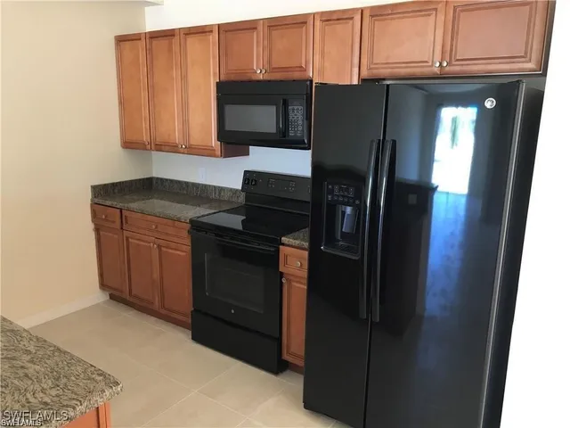 a kitchen with stainless steel appliances granite countertop a refrigerator and a stove top oven
