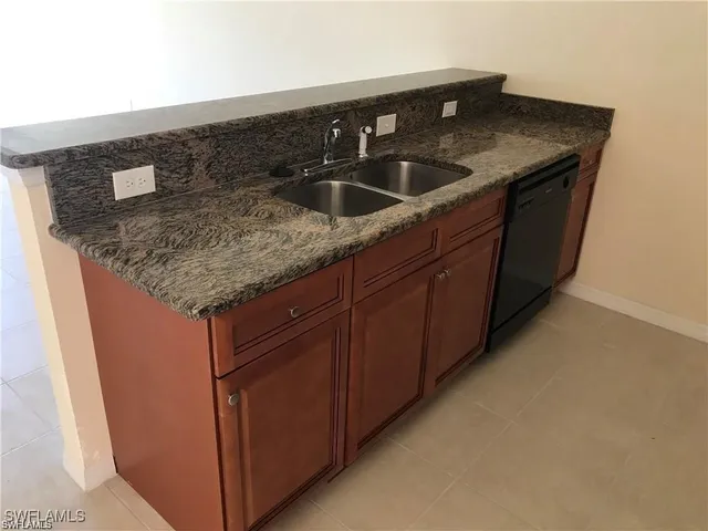a kitchen with granite countertop a sink and cabinets