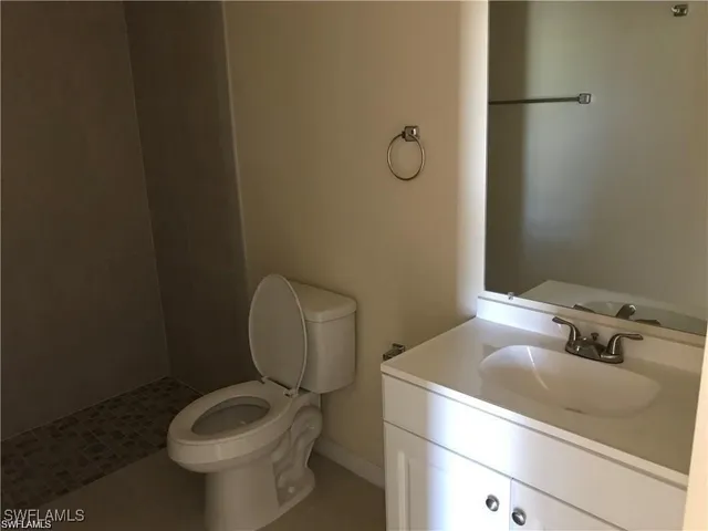 a bathroom with a sink toilet and mirror