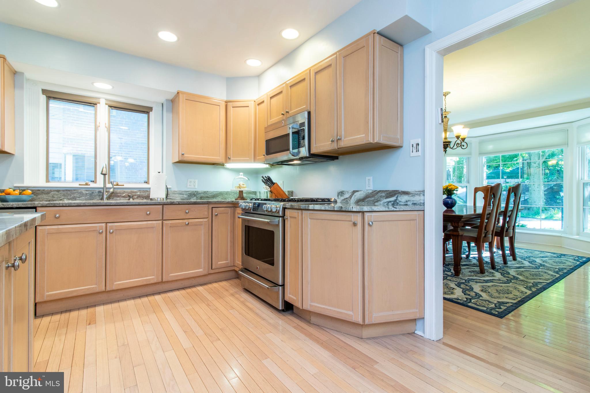 543 Hamilton Road Merion Station, PA 19066 - Photo 8 of 28 a kitchen with a stove a sink and white cabinets with wooden floors