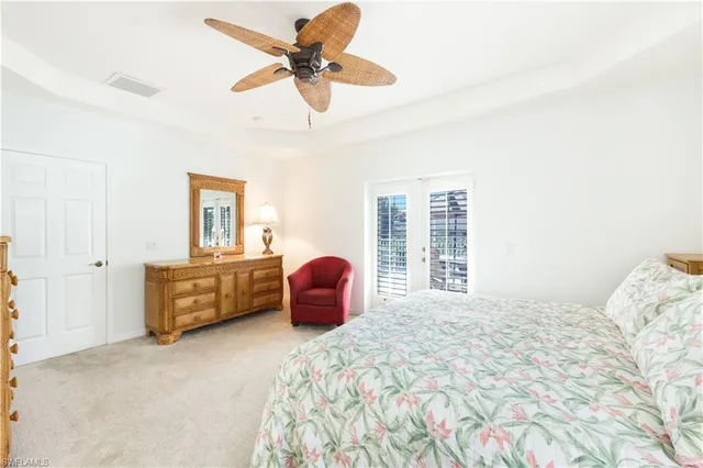 a bedroom with a large bed and a chandelier fan