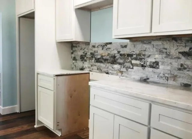 a kitchen with a white cabinets and a refrigerator