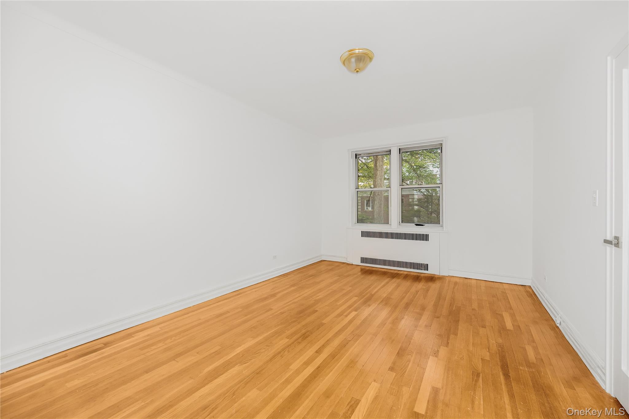 766 Palmer Road, Unit 2D Bronxville, NY 10708 - Photo 10 of 21 a view of empty room with window and wooden floor