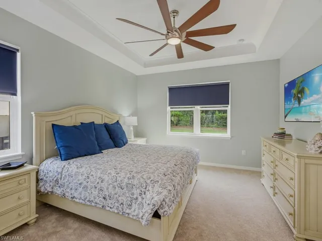 a bedroom with a large bed and a chandelier fan