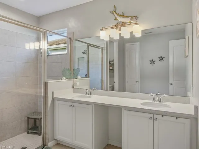 a bathroom with a double vanity sink mirror and toilet