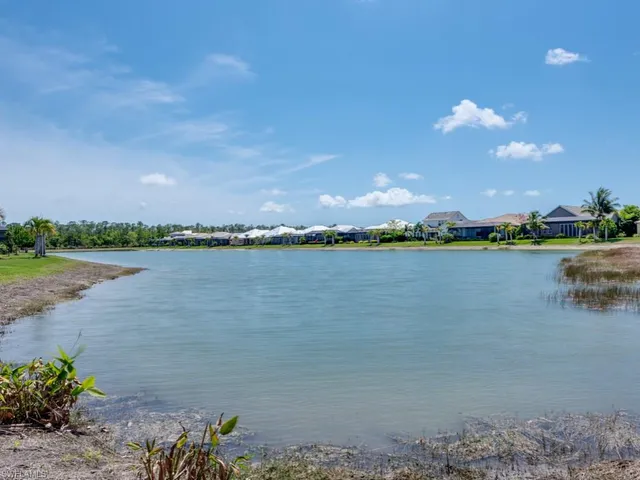 a view of a swimming pool with lawn chairs under an umbrella