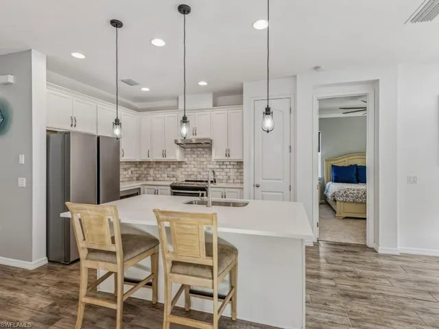 a large kitchen with a table chairs refrigerator and microwave