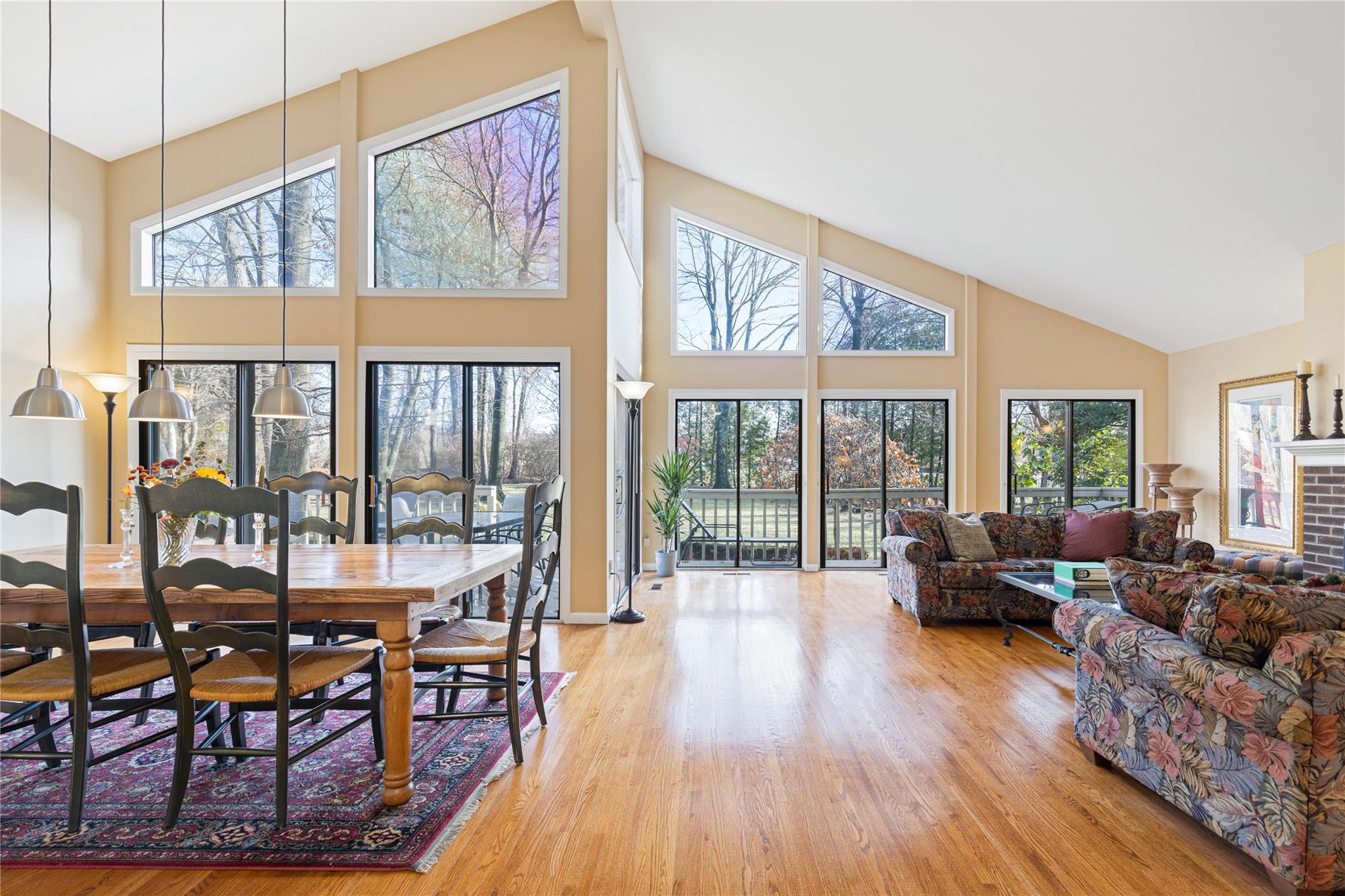 53 Talcott Road Rye Brook, NY 10573 - Photo 1 of 1 Dining room with wood-flooring, a brick fireplace, high vaulted ceiling, and a healthy amount of sunlight