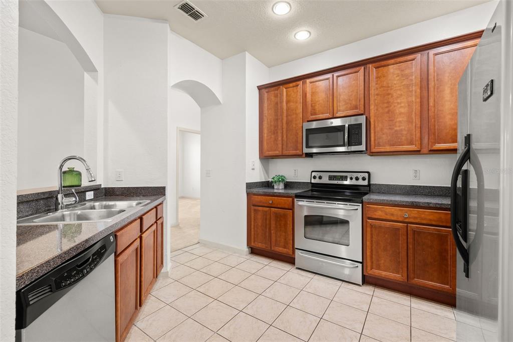 3025 Greystone Loop, Unit 204 Kissimmee, FL 34741 - Photo 11 of 37 a kitchen with a sink stove and microwave