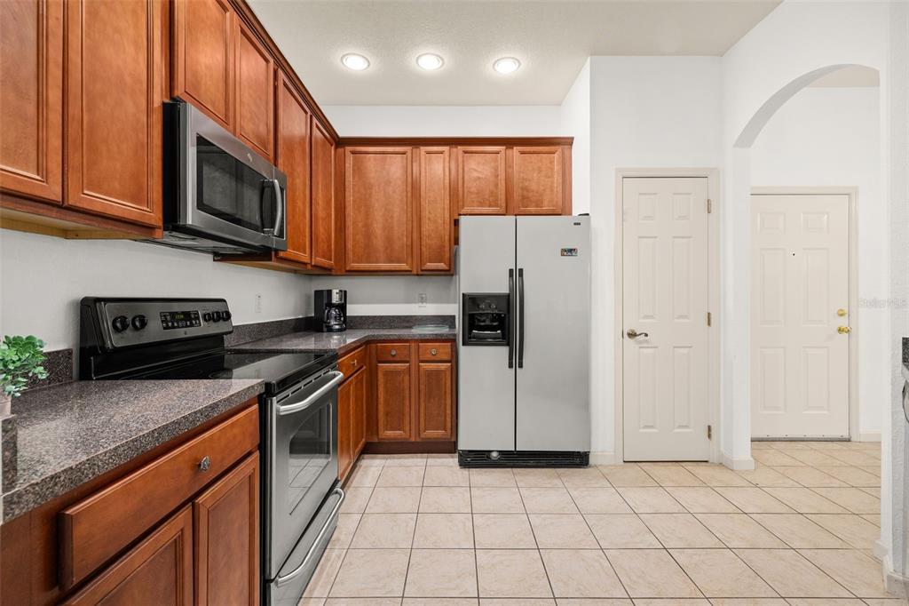 3025 Greystone Loop, Unit 204 Kissimmee, FL 34741 - Photo 12 of 37 a kitchen with stainless steel appliances granite countertop a refrigerator and a stove top oven