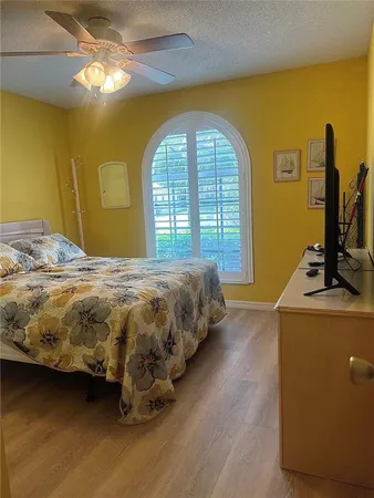 a bedroom with a bed and a flat tv screen on dresser