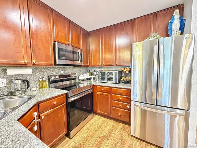 a kitchen with stainless steel appliances granite countertop a refrigerator stove microwave and sink
