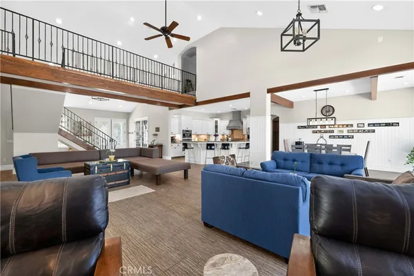 a living room with furniture kitchen view and a large window