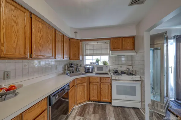 a kitchen with a sink a stove cabinets and wooden floor