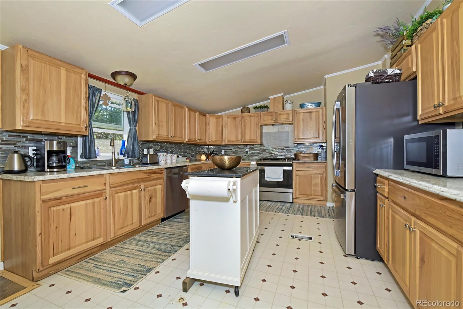 44 Southpark Road Florissant, CO 80816 - Photo 20 of 39 a kitchen with granite countertop a refrigerator stove top oven and sink
