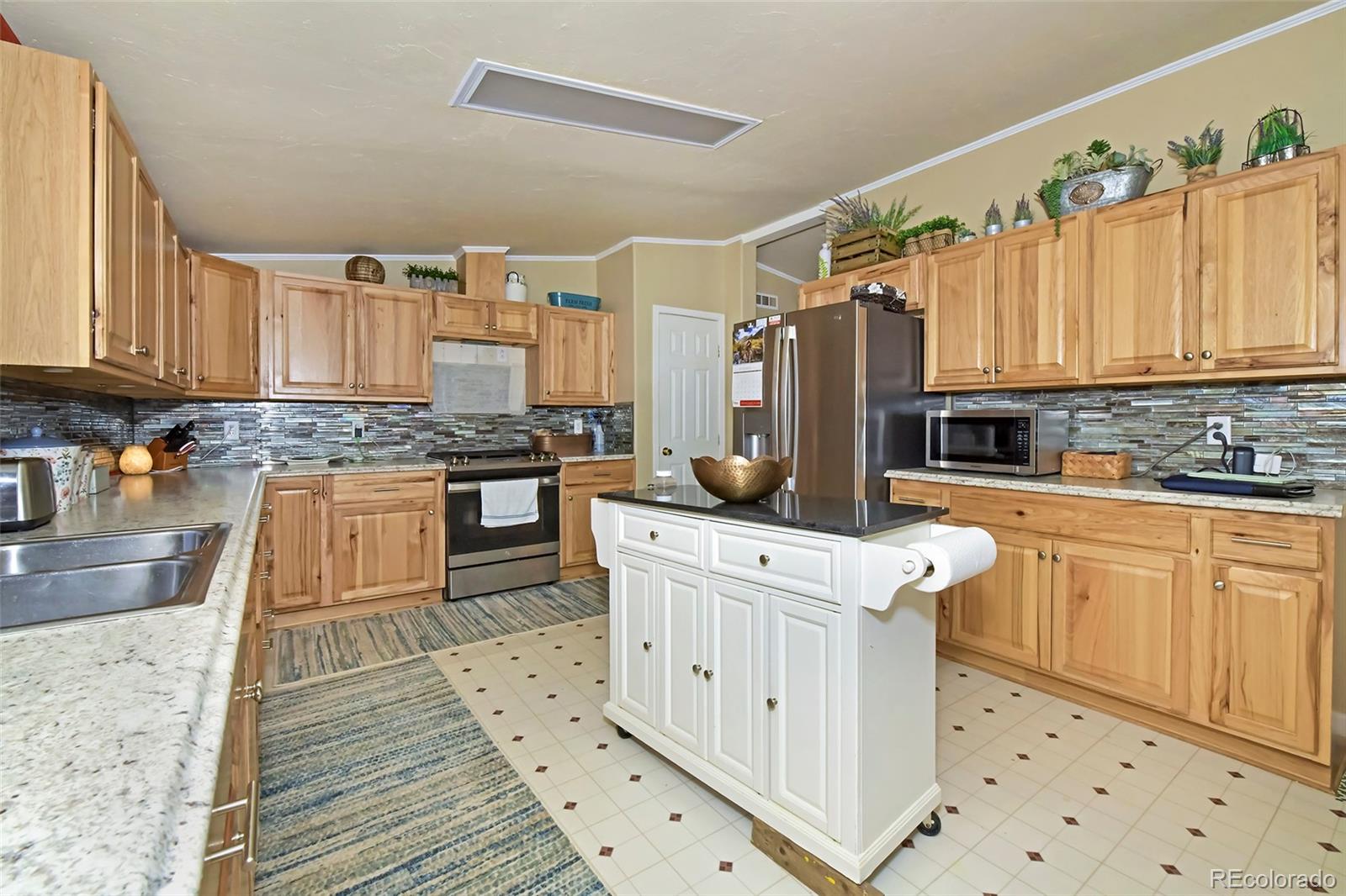 44 Southpark Road Florissant, CO 80816 - Photo 21 of 39 a kitchen with stainless steel appliances granite countertop a stove a sink and a refrigerator