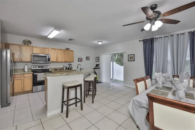 a kitchen with kitchen island granite countertop a sink cabinets and stainless steel appliances