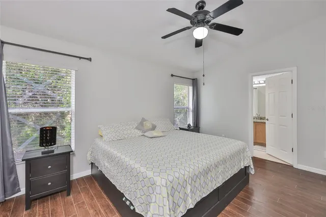 a bedroom with a bed and a chandelier fan