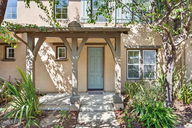 a front view of a house with a tree