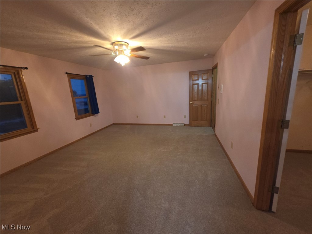 2291 Armstrong Road Wooster, OH 44691 - Photo 10 of 23 Master bedroom with carpet, a textured ceiling, and a walk in closet
