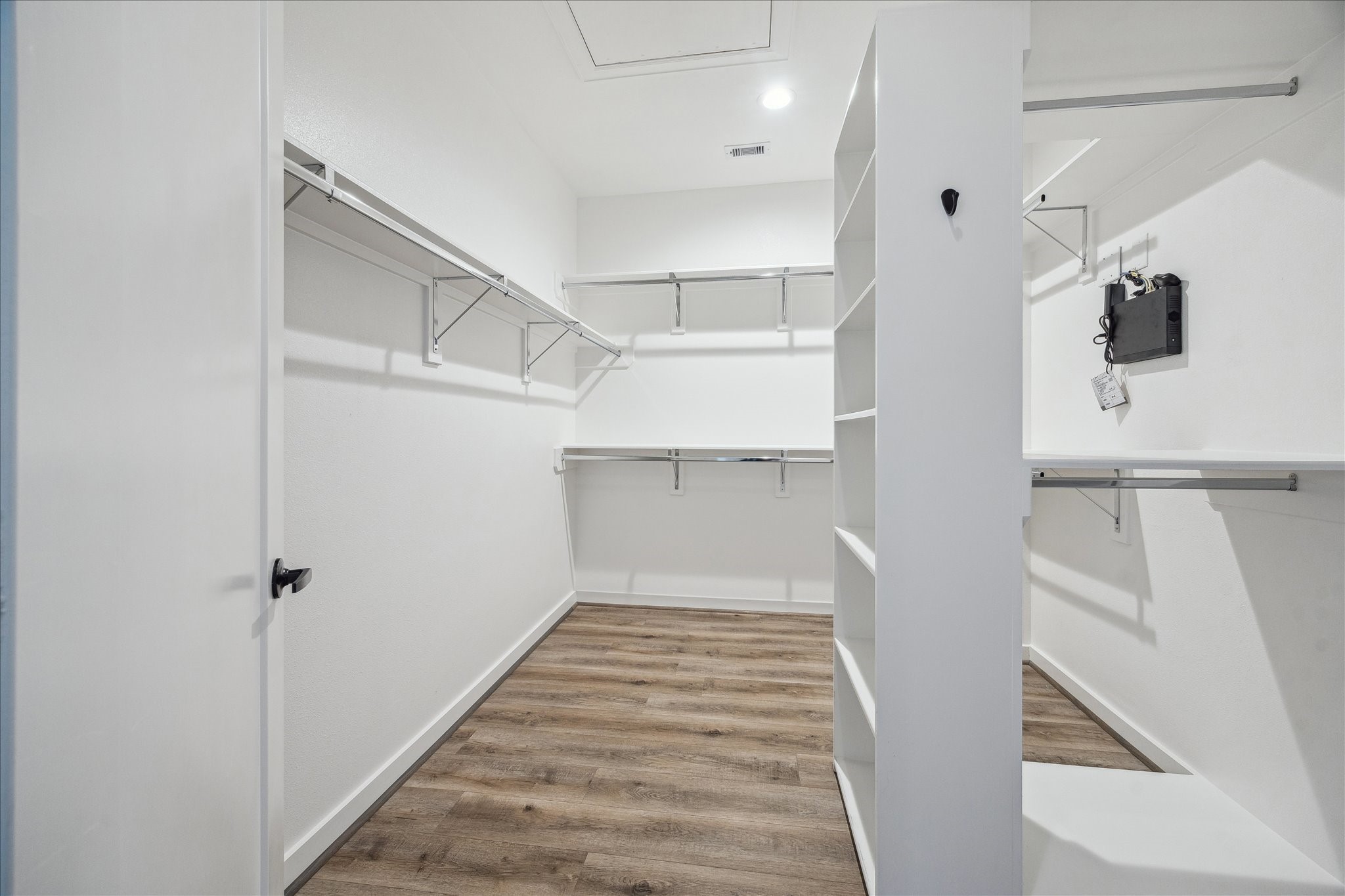 1603 Patterson Street, Unit E Houston, TX 77007 - Photo 25 of 32 Spacious walk-in closet with ample shelving and hanging space. Features clean white walls, modern fixtures, and wood-look flooring.